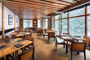 马姆莫斯湖猛犸湖威斯汀莫纳奇度假酒店的餐厅设有木桌、椅子和窗户。