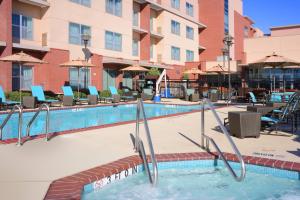 本殖民地Residence Inn by Marriott Dallas Plano The Colony的游泳池,酒店配有椅子和遮阳伞