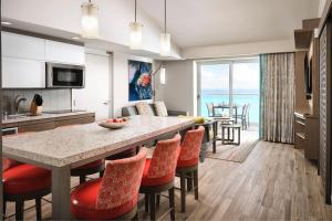 坎昆The Westin Cancun Resort Villas & Spa的厨房以及带桌椅的起居室。