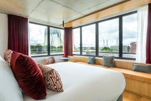 波尔多Renaissance Bordeaux Hotel的卧室设有白色的床和大窗户