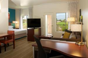棕榈荒漠棕榈沙漠原住客栈的酒店客房设有书桌,卧室配有一张床和电视。
