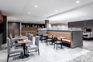 白鱼镇TownePlace Suites by Marriott Whitefish的一间带桌椅的餐厅和一间酒吧