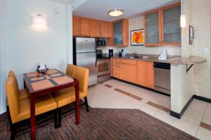 多佛尔多佛尔公寓式酒店的厨房配有木桌和冰箱。
