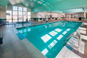 多佛尔多佛尔公寓式酒店的大楼内带椅子的大型游泳池