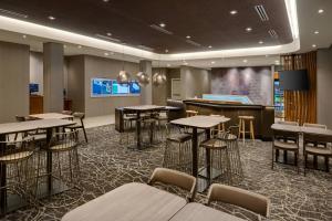 印第安纳波利斯SpringHill Suites by Marriott Indianapolis Keystone的一个带桌椅的会议室和一个舞台