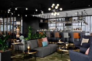 史基浦Renaissance Amsterdam Schiphol Airport Hotel的一间带沙发和桌子的餐厅和一间酒吧