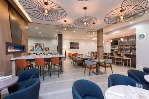 大急流城万豪大湍城机场德尔塔酒店的一间带桌椅的餐厅和一间酒吧