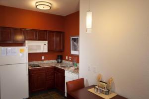 威奇托Residence Inn by Marriott Wichita East At Plazzio的厨房配有木制橱柜和白色冰箱。