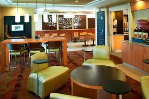 萨吉诺萨吉诺万豪广场套房酒店的餐厅设有酒吧,配有黄色的椅子和桌子