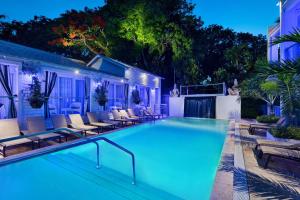 基韦斯特The Saint Hotel Key West, Autograph Collection的游泳池周围设有躺椅,晚上