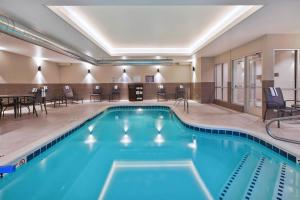 卡拉马祖Fairfield Inn & Suites by Marriott Kalamazoo的游泳池位于酒店客房内,配有桌椅
