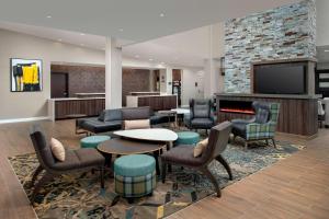 拉伯克Residence Inn by Marriott Lubbock Southwest的大堂设有桌椅和壁炉。