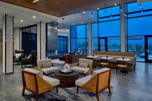 奥斯汀AC Hotel by Marriott Austin Hill Country的大堂设有桌椅和大窗户。