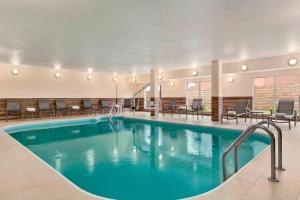 亨博尔休斯顿杭布尔费尔菲尔德套房客栈的酒店大堂的游泳池,配有桌椅