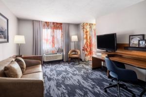 盐湖城盐湖城市中心费尔菲尔德酒店及套房的酒店客房设有一张沙发和一张带电视的书桌。