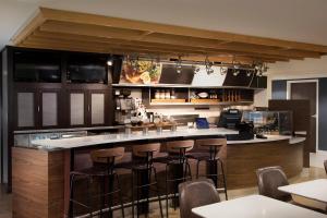 温斯顿·塞勒姆塞勒姆大学温斯顿万怡酒店 的厨房设有带凳子的酒吧