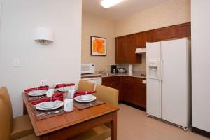 博伊西博伊西西部住宿客栈的厨房配有桌子和白色冰箱。