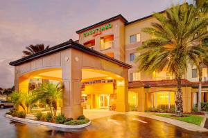 西棕榈滩Courtyard by Marriott West Palm Beach Airport的前面有棕榈树的酒店