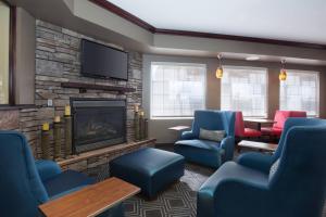 波卡特洛波卡特洛唐普雷斯套房酒店的一间设有蓝色椅子和壁炉的等候室