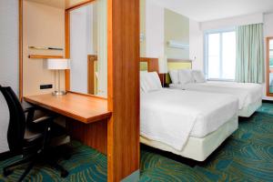 奥古斯塔奥古斯塔万豪春丘酒店的酒店客房设有两张床、一张桌子和一面镜子
