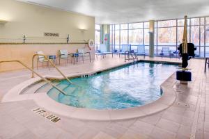 奥古斯塔奥古斯塔万豪春丘酒店的一个带桌椅的健身房内的游泳池