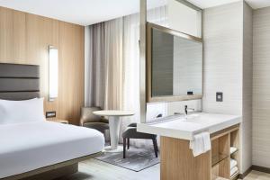 休斯顿AC Hotel by Marriott Houston Downtown的一间卧室配有床、水槽和镜子