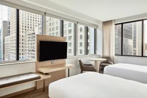 休斯顿AC Hotel by Marriott Houston Downtown的酒店客房设有两张床和一台平面电视。