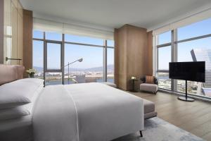 福州福州东湖万豪酒店的卧室设有一张白色大床和大窗户