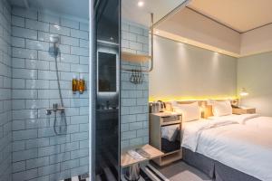 台中市城市漫游行旅的带淋浴的浴室和客房内的一张床
