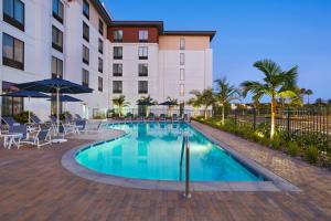 圣地亚哥TownePlace Suites by Marriott San Diego Airport/Liberty Station的酒店前方的游泳池配有椅子和遮阳伞