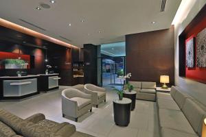 TocumenCourtyard by Marriott Panama Metromall的客厅配有沙发、椅子和桌子