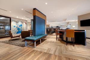 门罗TownePlace Suites by Marriott Monroe的一个带桌椅的大堂和一间用餐室