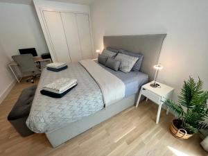 直布罗陀Modern Apartment with Spa and Pool的一间卧室配有床、桌子和植物