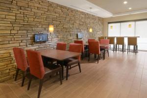 隆娜特里南丹佛/隆特里万豪广场套房酒店的一间设有桌椅的用餐室和砖墙
