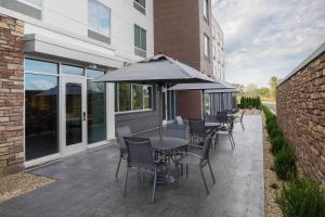 欢乐草原Fairfield Inn & Suites by Marriott Kenosha Pleasant Prairie的一个带桌椅和遮阳伞的庭院
