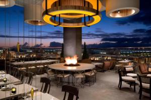 圣地亚哥圣地亚哥煤气灯区万怡酒店/会议中心的一间带桌椅和火坑的餐厅