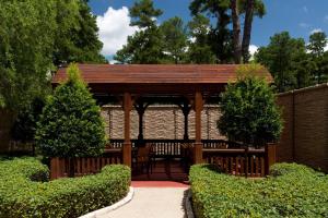 特克萨卡纳-德克萨斯特克萨卡纳万怡酒店的灌木花园中的木制凉亭