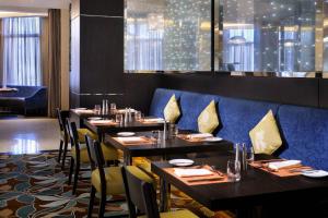 利雅德玛利雅特外交区万怡利雅得酒店的一间带桌椅和蓝色沙发的餐厅