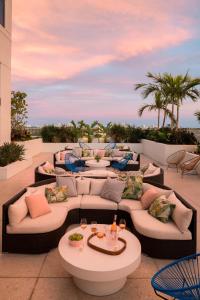 劳德代尔堡The Dalmar, Fort Lauderdale, a Tribute Portfolio Hotel的一个带沙发和桌子及棕榈树的庭院