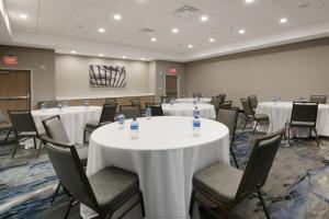 达拉斯Fairfield by Marriott Inn & Suites Dallas East的配有桌椅和白色桌布的房间