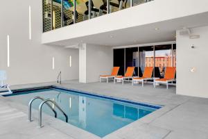 达拉姆达拉姆市中心雅乐轩酒店的一座带橙色椅子的建筑中的游泳池