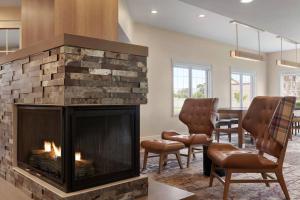 萨利纳斯Residence Inn by Marriott Salinas Monterey的客厅设有壁炉和椅子