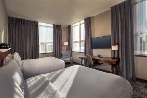费城费城市中心福朋喜来登酒店的酒店客房设有两张床、一张桌子和一台电视。
