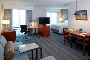 明尼阿波利斯明尼阿波利斯市中心酒店的酒店客房设有一张床和一个带沙发的客厅