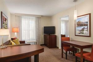 米德尔敦Residence Inn by Marriott Newport Middletown的酒店客房配有书桌和电视。