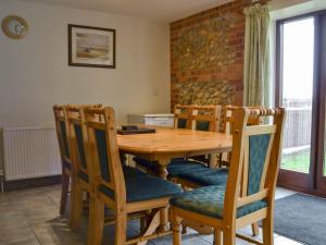 BawdeswellChurch Farm Barn - Ukc3739的一间带木桌和椅子的用餐室
