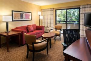 圣安娜梅萨海岸南海岸新城万怡酒店的酒店客房设有沙发、椅子和电视。