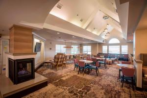 彭萨科拉Residence Inn by Marriott Pensacola Downtown的大型客房设有壁炉、桌子和椅子。