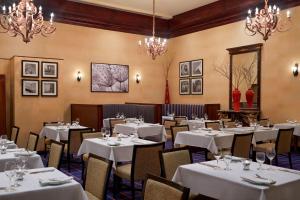 渥太华渥太华喜来登酒店的餐厅设有白色的桌椅和吊灯。