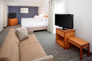 列克星敦列克星敦北原住酒店的酒店客房设有沙发、电视和床。